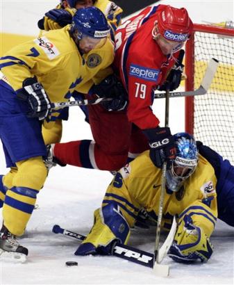 Brank Henrik Ludquist a obrnce Niklas Kronwall zasahuj proti Alexeji Yainovi. Autor - AP Photo/Frank Gunn, CP